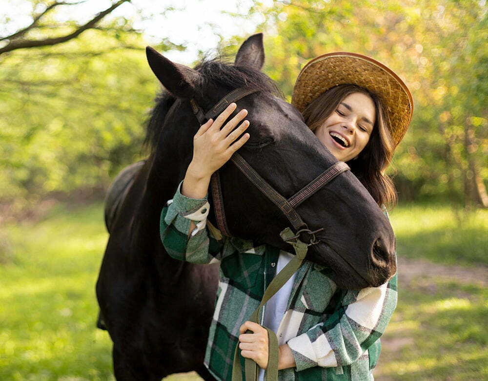 Femme qui rit avec un cheval